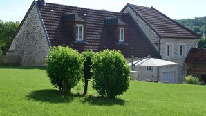 A stone house with a sloped roof and two small windows.