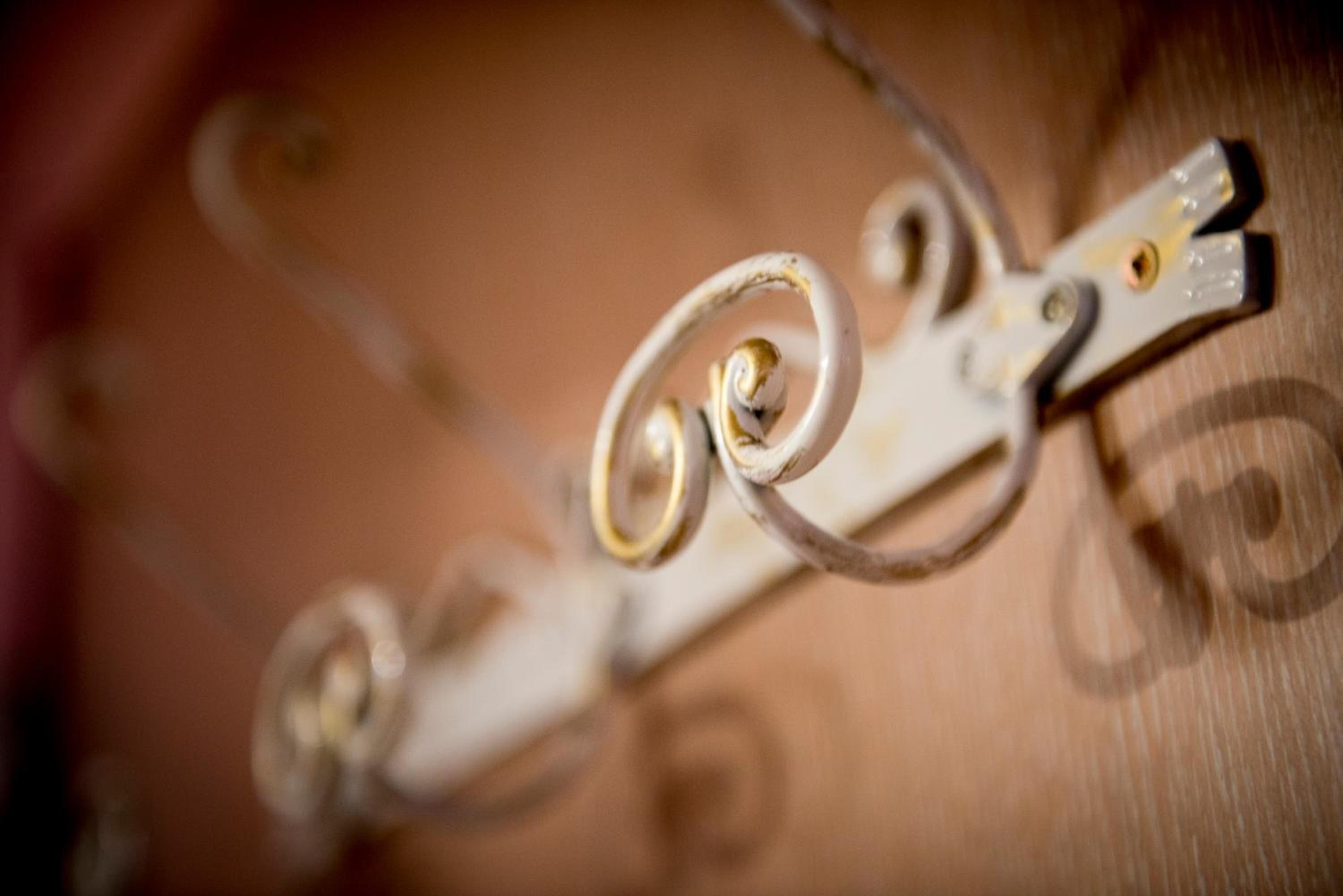 A close-up of a metallic object with a spiral design, possibly a part of a piece of furniture or equipment.