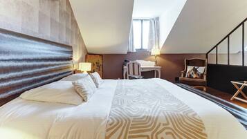 Une chambre d’hôtel avec un grand lit, un bureau, une chaise, une lampe et une statue de cheval.