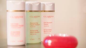 Drie Clarins Paris huidverzorgingsproducten op een reflecterend oppervlak.