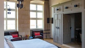 A bedroom with a bed, a chandelier, a wardrobe, and a window. - La Ferme du Château (Anthenay)
