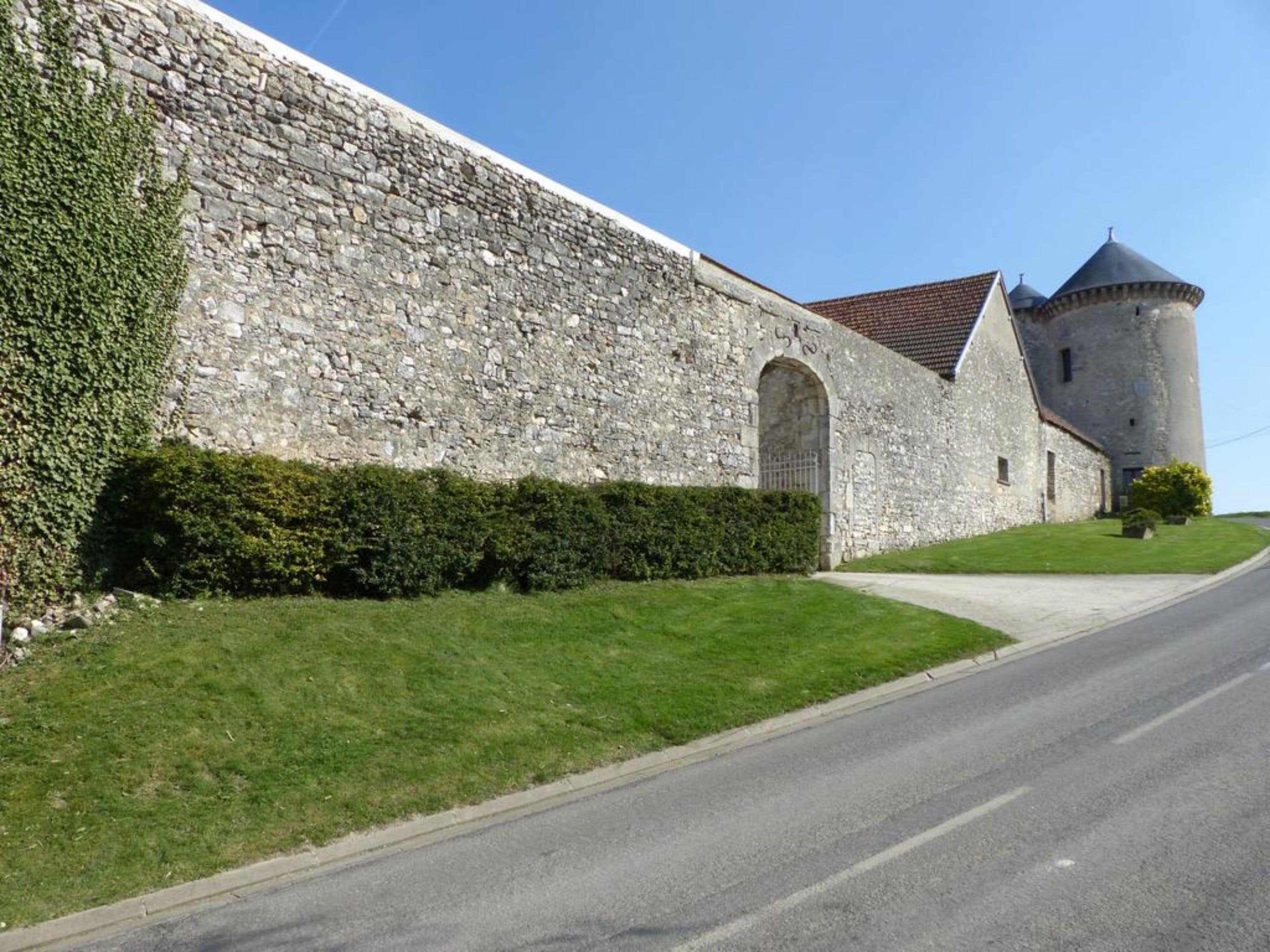 A stone building with a cylindrical tower and arched entrance.