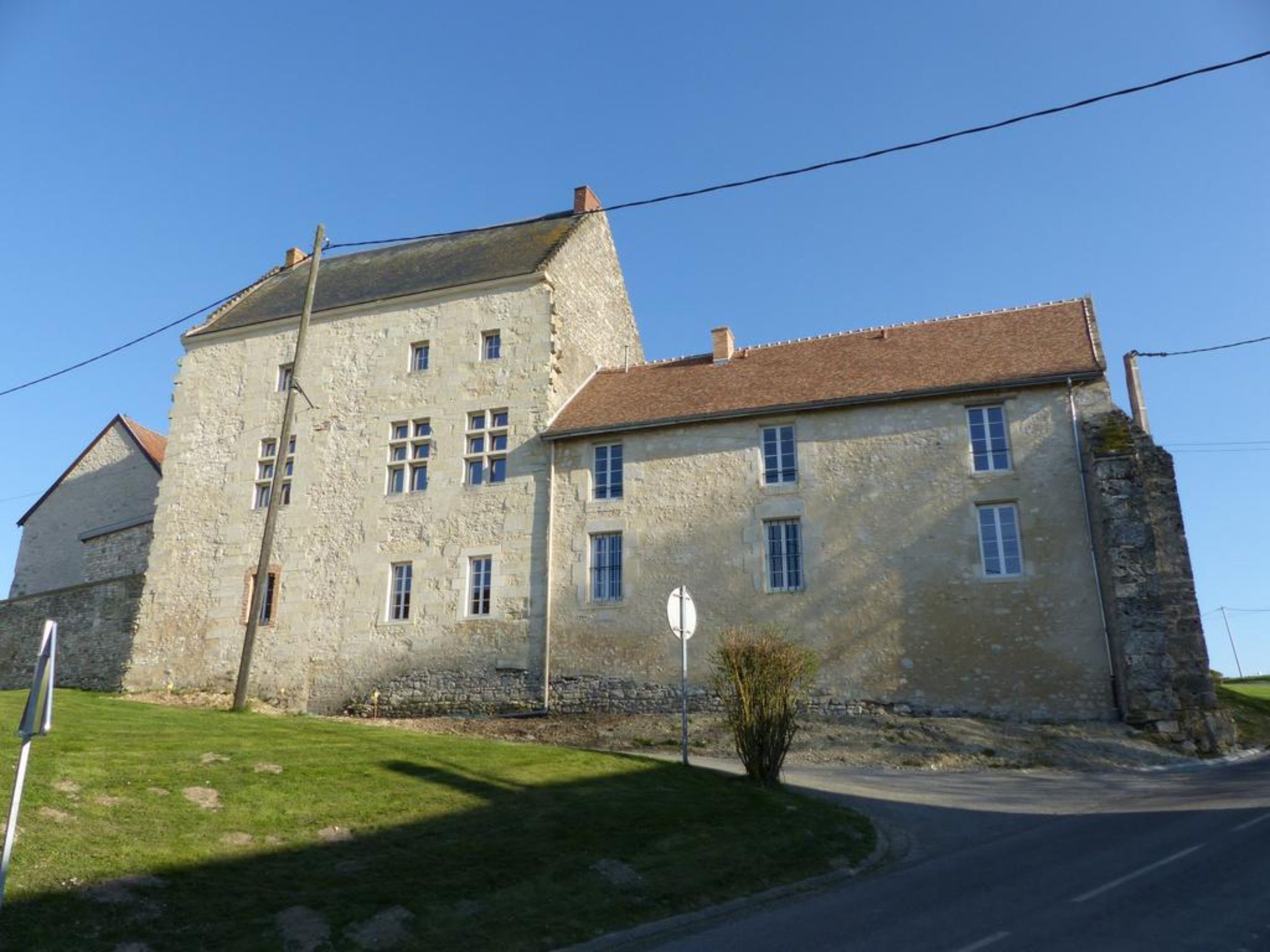 A large stone building with multiple windows and a sloped roof.