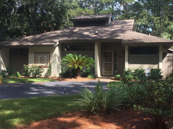 Stunning single-story home with a charming front porch and beautifully manicured lawn.