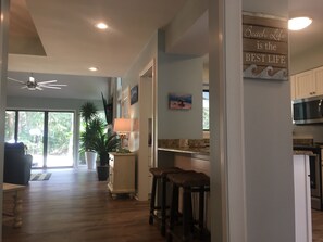 Relax in a spacious, open-plan area with a high ceiling and modern kitchen, perfect for casual dining or socializing.