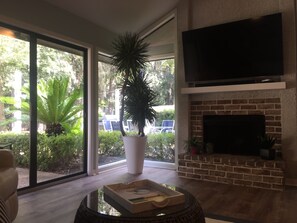 Relax in a spacious living room with a comfortable seating area, flat-screen TV, and brick fireplace.