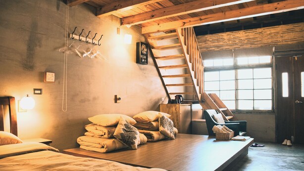 A cozy room with a bed, a wooden bench, and a staircase. - Loku.Tainan (Tainan)