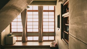A room with a large window, a wooden desk, and a shelf with decorative items. - Loku.Tainan (Tainan)