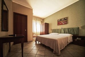 A bedroom with a bed, a desk, a wardrobe, and a painting on the wall. - Hotel La Brocca (Fonte Nuova)