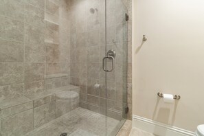 Een douche, handdoeken, shampoo, toiletpapier