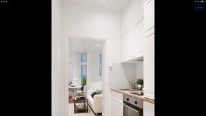 A modern kitchen with white cabinetry, a stainless steel sink, and a built-in oven. - Apt. Odins Gate (Oslo)