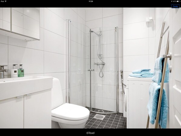 A modern bathroom with a toilet, sink, and shower.