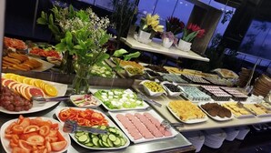 En buffé med ett varierat utbud av mat, inklusive frukt, grönsaker och kött.