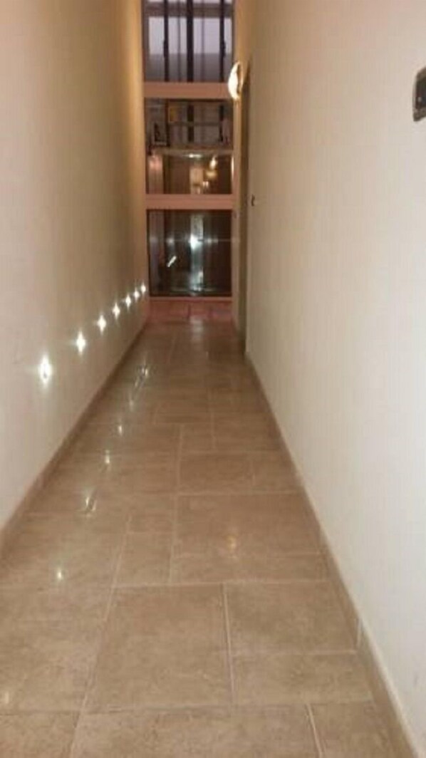 A corridor with tiled flooring and a staircase leading to a second floor. - B&B Manzoni Resort (Brindisi)