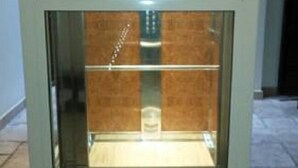 A glass-fronted elevator with a wooden interior and a metal railing. - B&B Manzoni Resort (Brindisi)
