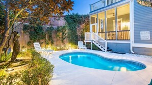 A swimming pool with lounge chairs, a staircase leading to a balcony, and a fenced garden area. - Newly Renovated 1890 Victorian Downtown Home w/ Heated Pool by Lucky Savannah (Savannah)