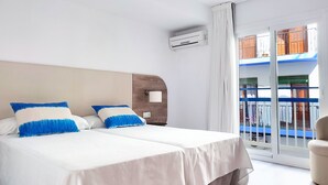 A hotel room with two beds, a large window with a view of a balcony, and an air conditioning unit on the wall. - Hotel Flats Friends Mar Blau (Benidorm)