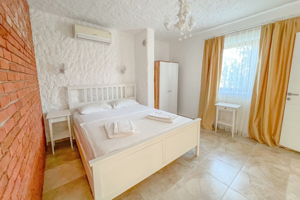 Ein Schlafzimmer mit Bett, Kleiderschrank, Schreibtisch und Stuhl.