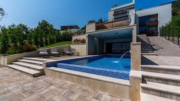 Piscine extérieure, parasols de plage, chaises longues