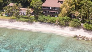 A beachfront property with clear turquoise water, a sandy beach, and lush greenery. - Vivere Azure (Mabini)