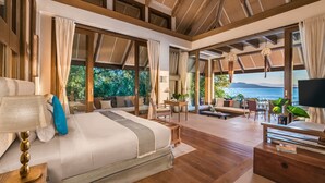 A spacious bedroom with a large bed, a TV, and a view of the sea. - Vivere Azure (Mabini)