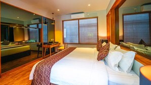 A hotel room with a large bed, a desk, a chair, a mirror, and a window with blinds. - Agranusa Signature Villa (Nusa Dua)