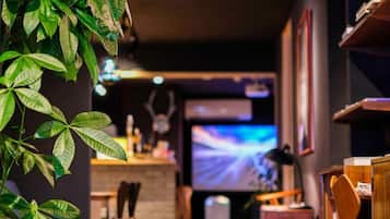A cozy indoor space with seating, a television, and a plant.