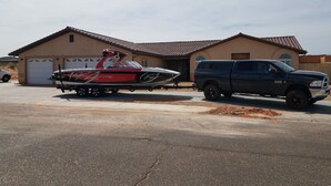 A house with a garage, a boat trailer, and a pickup truck parked in front. - Rustic home, spacious, clean, great for boaters, families, fishermen, business (Page)