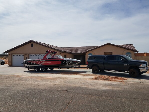 A house with a garage, a boat trailer, and a pickup truck parked in front. - Rustic home, spacious, clean, great for boaters, families, fishermen, business (Page)