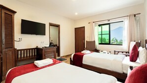A hotel room with two beds, a TV, a wooden wardrobe, a desk with a kettle, and a window with a mountain view. - The Culture Resort (Pokhara)