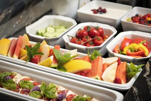Ein Buffet mit verschiedenen Obst- und Gemüsesorten in weißen Tabletts.