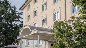 Un hôtel à plusieurs étages doté d’une entrée couverte et d’un espace de stationnement.