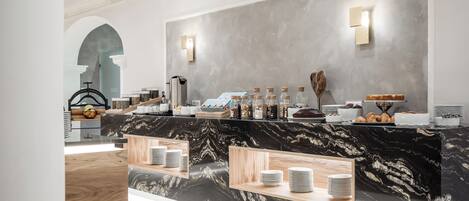 A modern hotel lobby with a marble reception desk, a large mirror, and a seating area with a wooden bench.