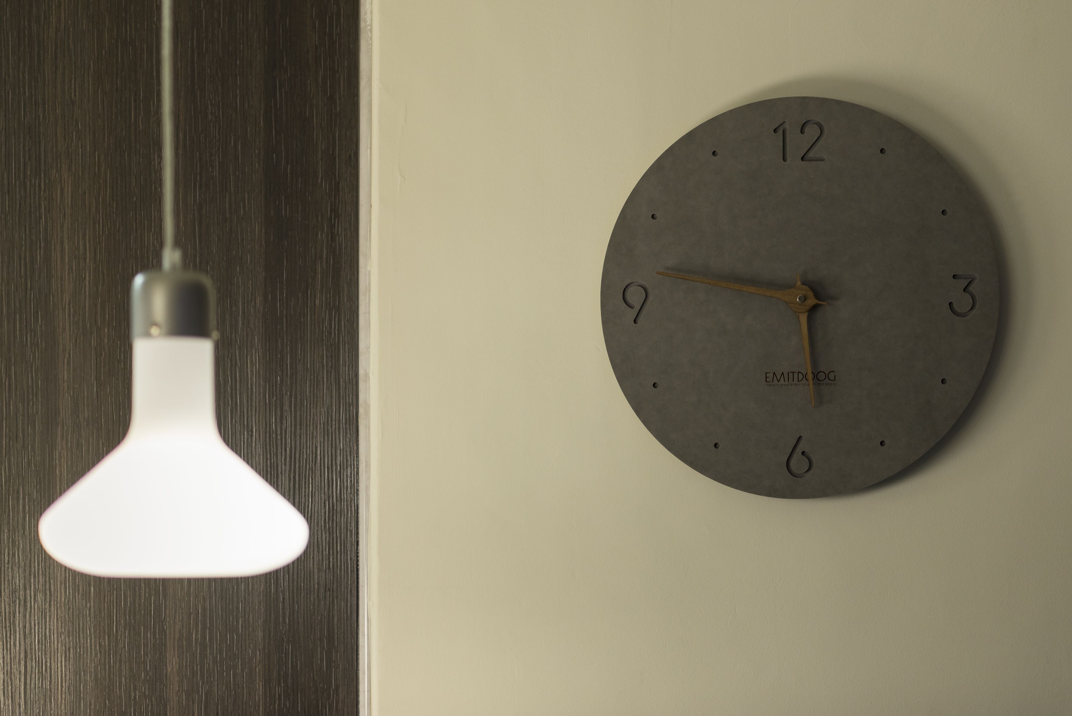 A wall clock with a minimalist design, mounted on a plain wall.