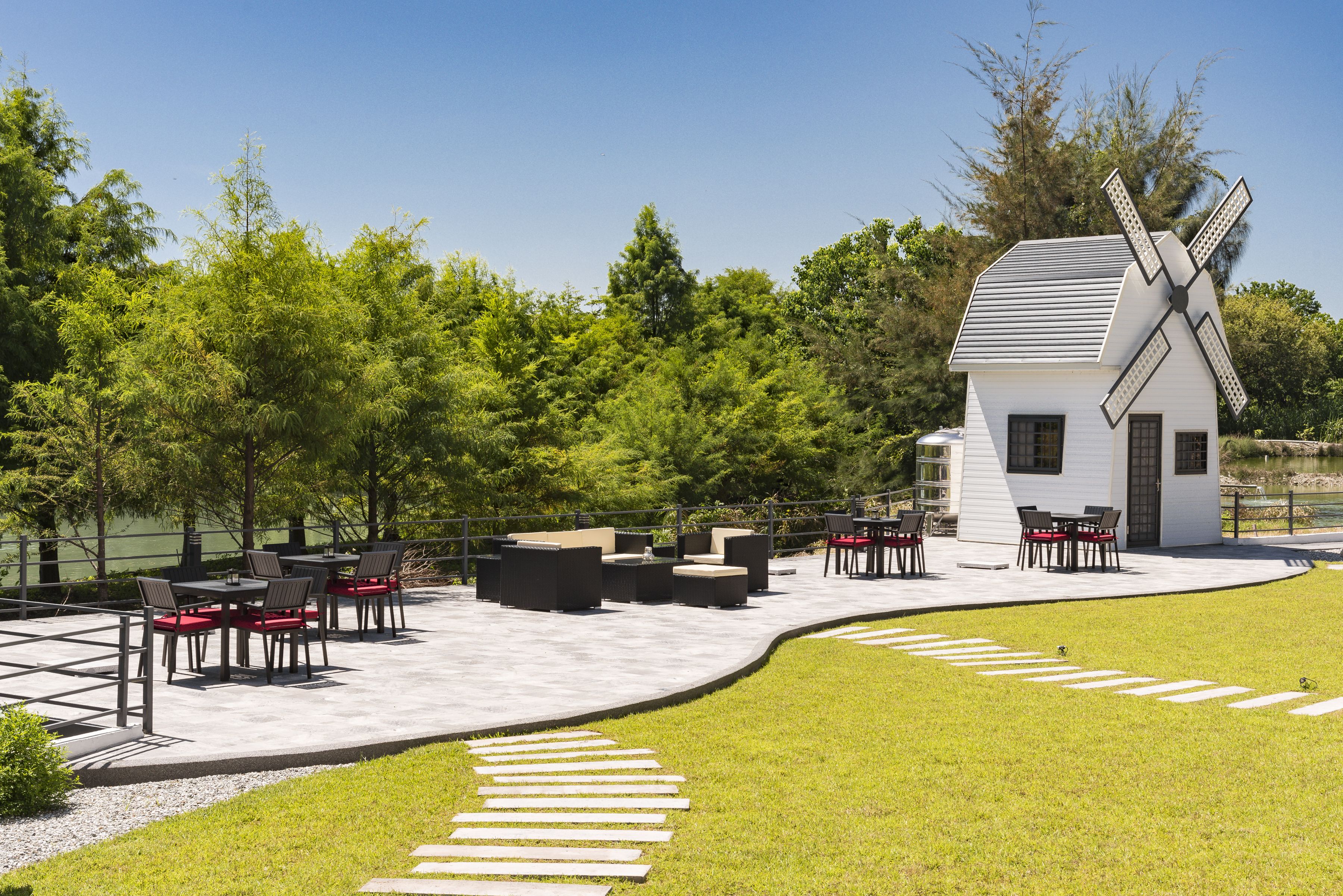 A windmill, outdoor seating area, and a pathway.