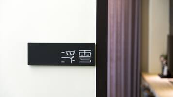 A black sign with white characters on a white wall.