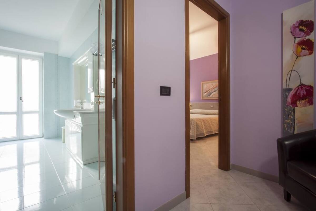 A modern bathroom with a glass shower enclosure, a white sink, and a mirror.