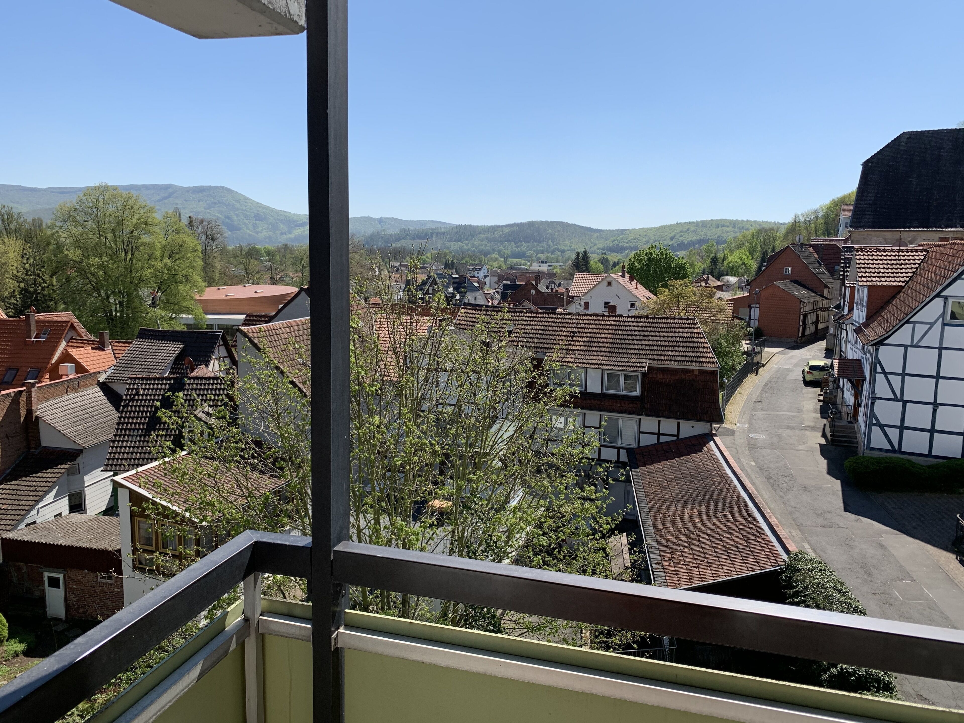 A residential area with traditional houses, a clear sky, and distant mountains.