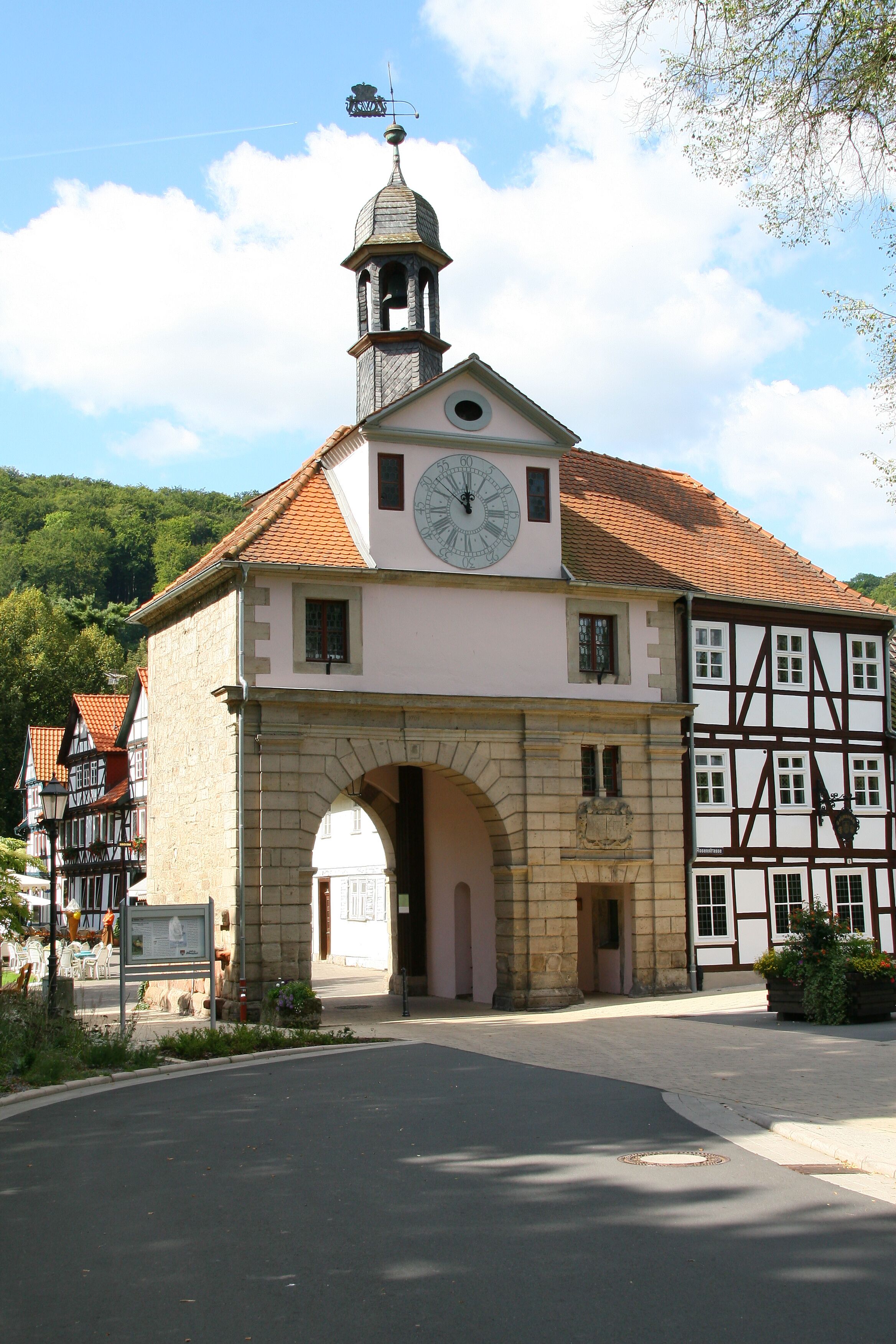 Un edificio histórico con una torre de reloj, una entrada en arco y arquitectura tradicional de entramado de madera.