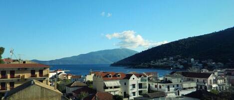 A coastal town with buildings, a clear sky, and a mountain in the background.