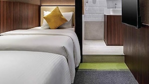 A modern hotel room with a bed, a TV, a bathroom with a sink, and a mirror. - Aerotel Cebu (Lapu-Lapu)