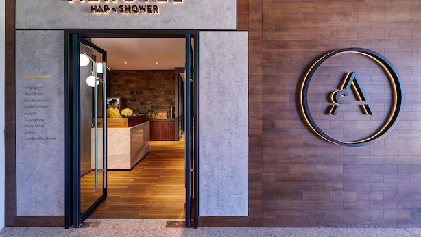 A hotel entrance with a reception desk, a wall-mounted logo, and a list of destinations. - Aerotel Cebu (Lapu-Lapu)