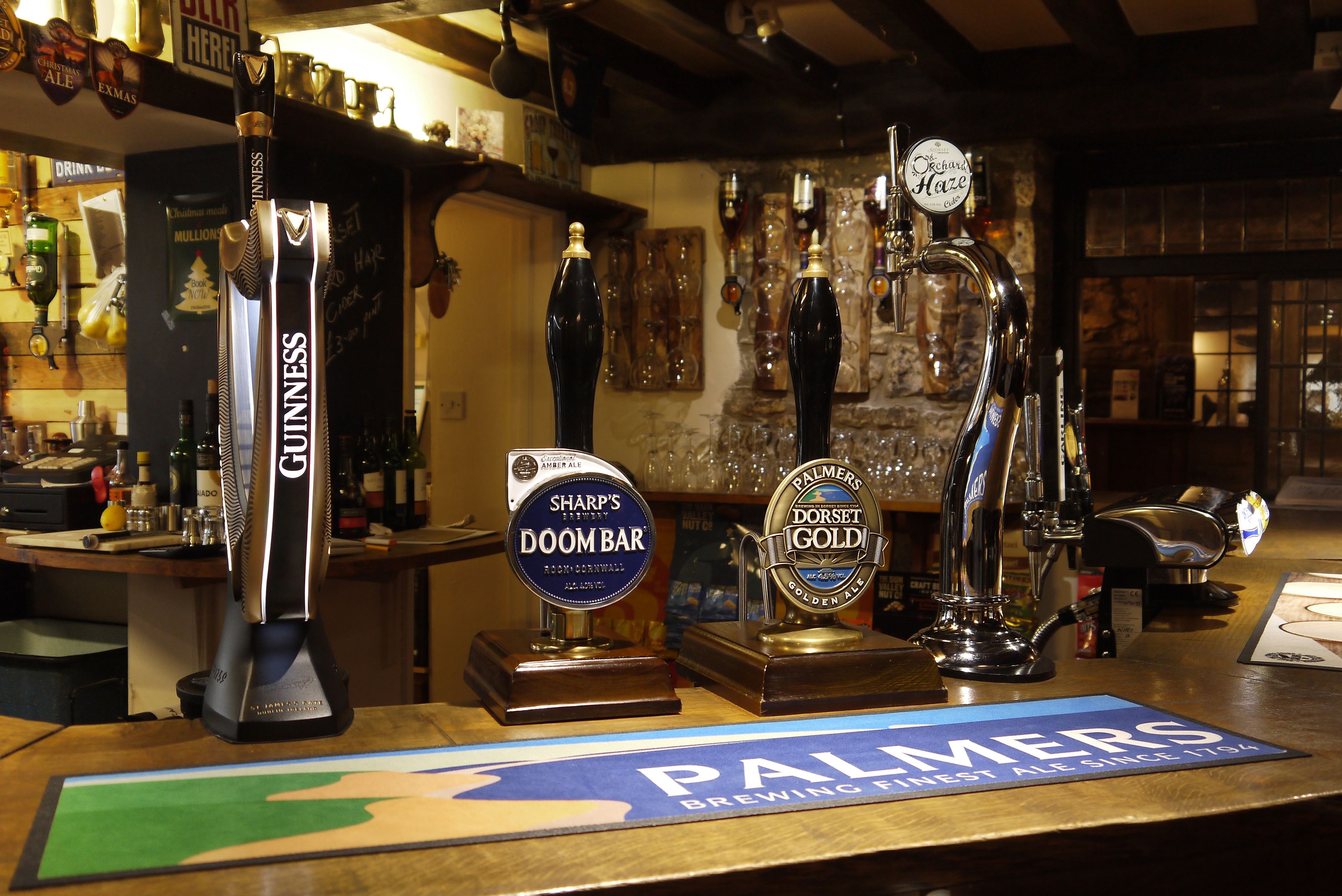 A bar with various beer taps, including Guinness, Doom Bar, and Palmer's Brewing.