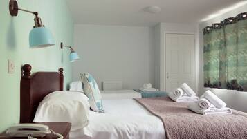 Een hotelkamer met twee bedden, een telefoon en een raam met gordijnen.