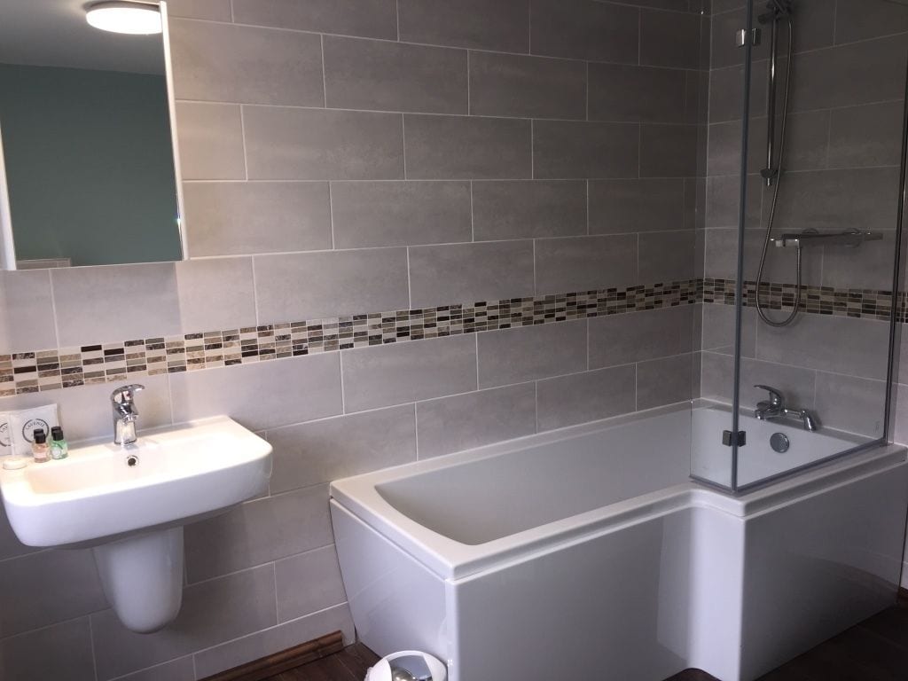 Une salle de bain avec un lavabo blanc, une baignoire et une douche.