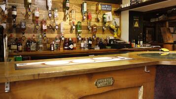 Zona de bar con varios dispensadores de licores y una barra de madera.