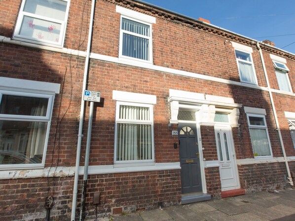 A two-story brick building with a ground-floor entrance and upper-floor windows. - Townhouse @ Newlands Street Stoke (Stoke-on-Trent)