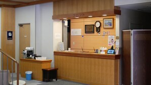 A reception desk with a coffee machine, a trash bin, and a clock on the wall. - KKR Kawayu (Teshikaga)