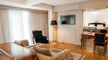Una sala de estar bien iluminada con un sofá, una mesa de comedor y un televisor montado en la pared.