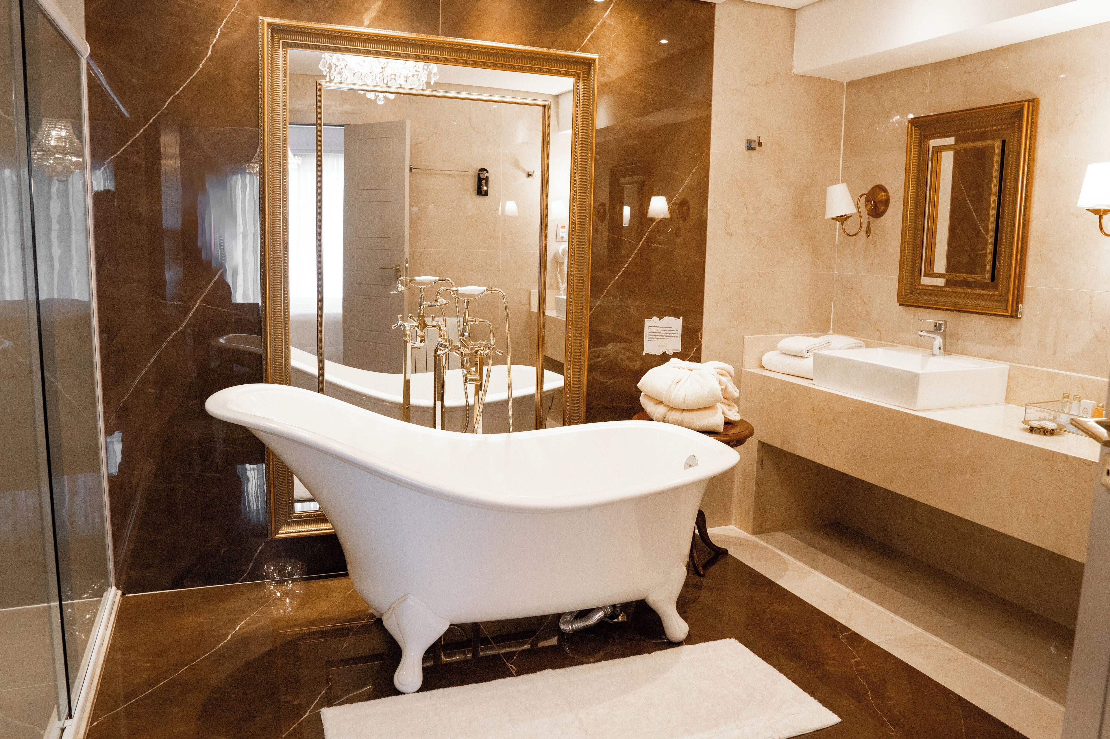 A modern bathroom with a freestanding bathtub, a large mirror, and a vanity with a sink.